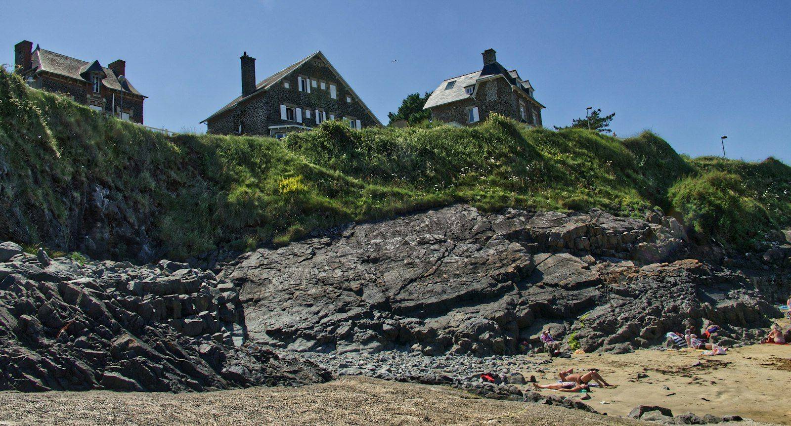 A rocky cove below granite houses on the Normandy coast