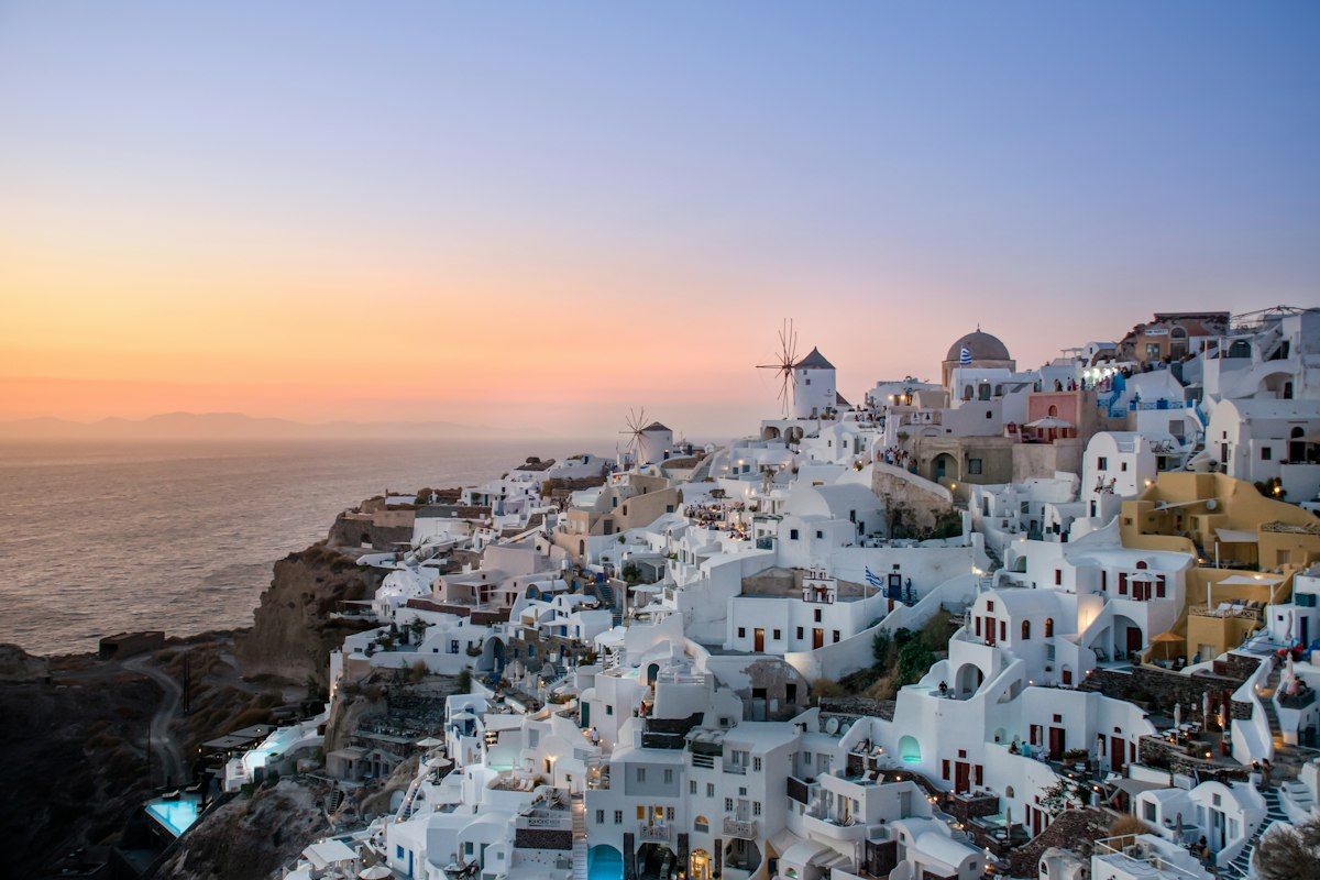 Whitewashed Greek island village on a cliff at sunset