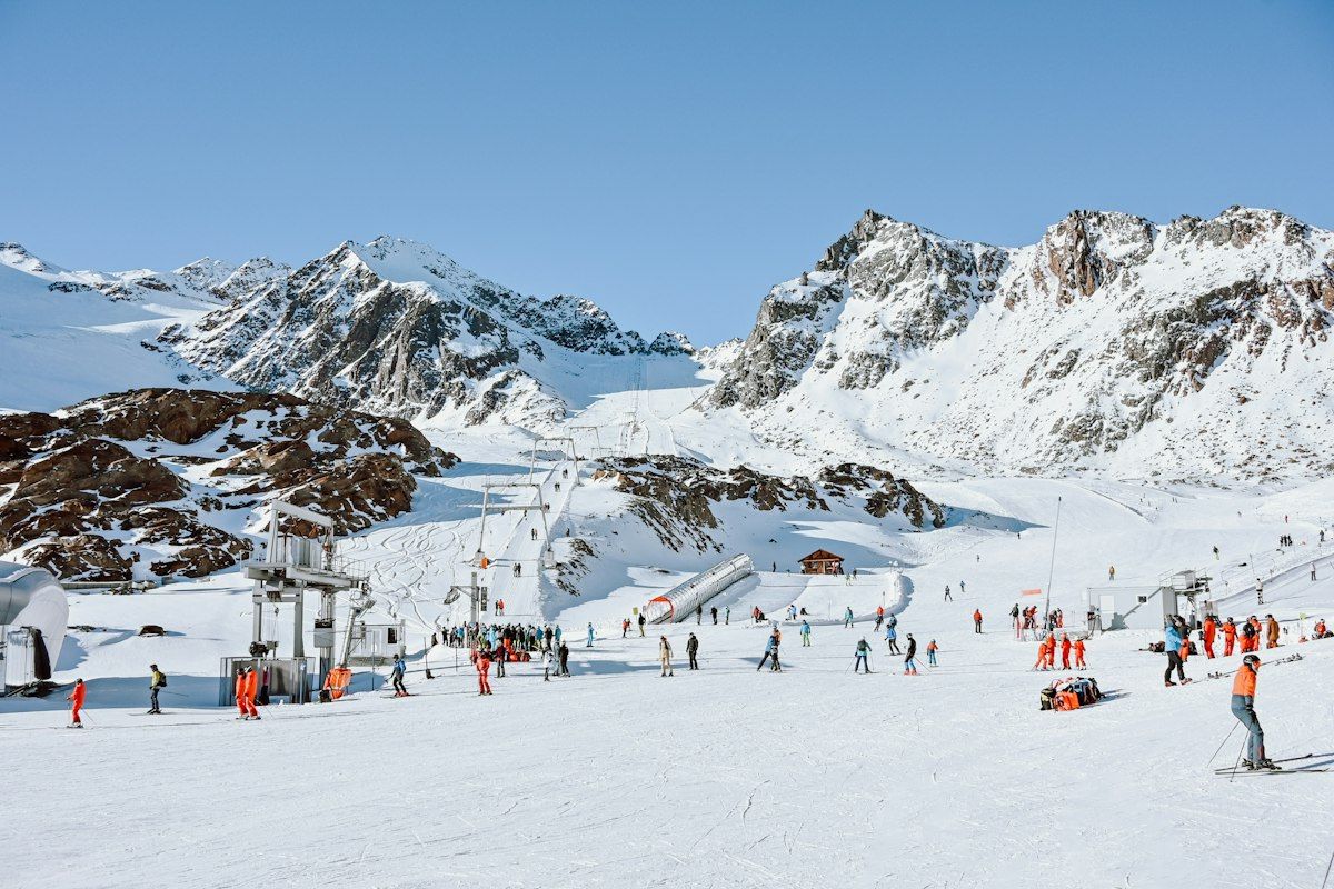 Skiers on a snow-covered slope near a mountain lodge